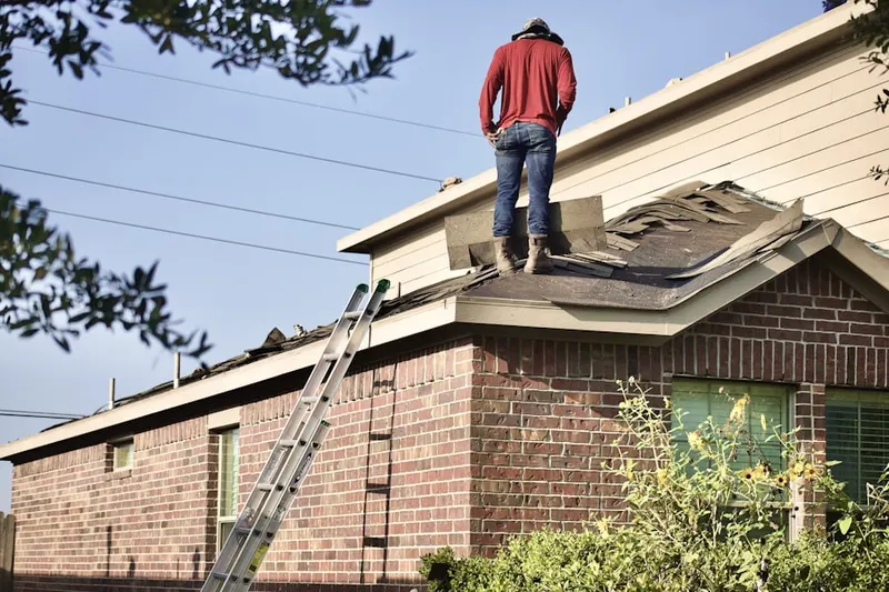 Professional roofer working on a residential roof in Bergen Mills